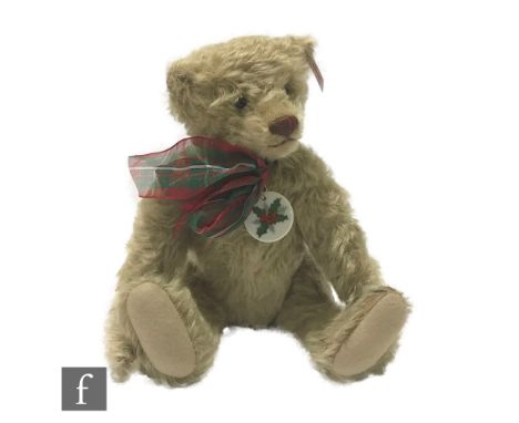 A Steiff Amelia Holiday Bear, blonde mohair, white tag 681400, limited edition of 2009, wearing festive ribbon with ceramic t