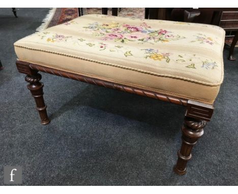 A late 19th to early 20th Century footstool of rectangular form, later upholstered in a floral patterned woodwork tapestry pa