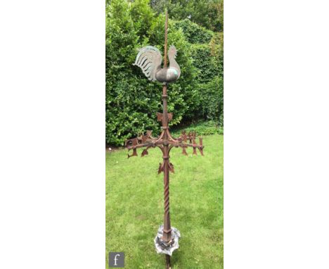 An early 20th Century wrought iron and copper weather vane, the copper cockerel wind direction indicator above the four compa