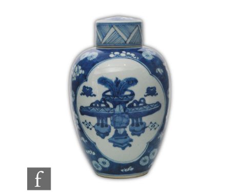 A Chinese Kangxi style blue and white vase, of ovoid form surmounted by a domed cover, the cracked ice ground picked out with