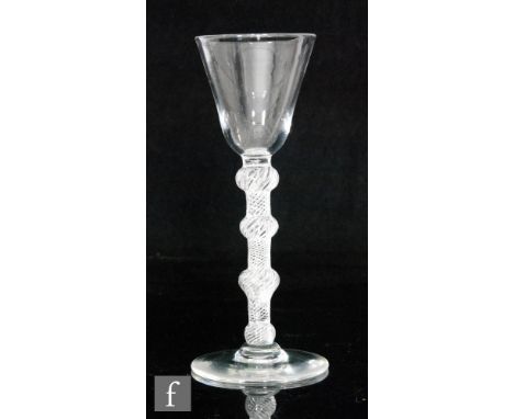 An 18th Century wine glass, circa 1755, the round funnel bowl above a multiple spiral air twist stem with four knops and rais