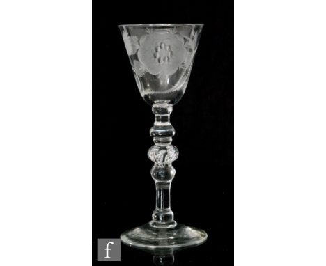 An 18th Century Jacobite drinking glass, circa 1760, the round funnel bowl wheel engraved with a rose in bloom on stem with a