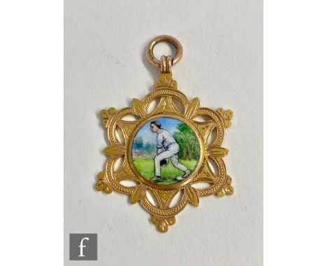 An early 20th Century 9ct fob with a enamelled centre panel depicting a man playing bowls, diameter 3.5cm weight 8g, stamped.