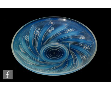 A 1930s Art Deco pressed glass bowl by Choisy-le-Roi of shallow circular form, relief moulded with stylised spiralling bull r