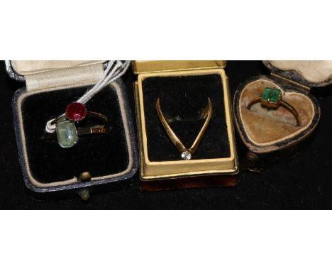 A 22ct gold and solitaire emerald ring and three other rings.