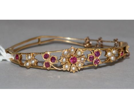 A seed pearl and gem set pierced gold hinged child's bangle.