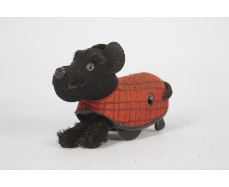 Schuco - A vintage Schuco clockwork dog with plaid coat. The dog is 12 cm long and shows some signs of age and use, its still
