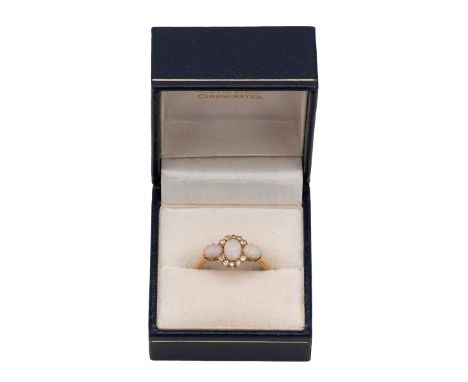 An 18ct gold opal and diamond ring the central opal surrounded by two half banks of five diamonds and flanked by two oval sha