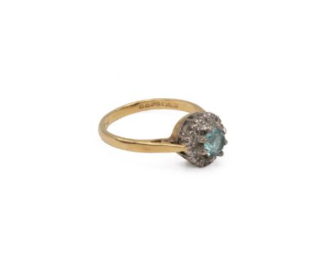18ct Gold Ring Set with Aquamarine mounted in an eight claw setting surrounded by a border of diamonds size K weight 3.0 gram