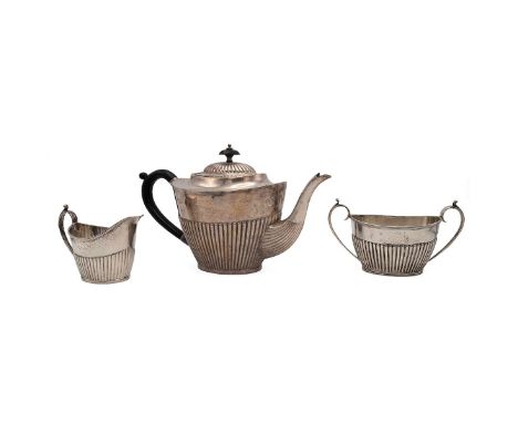 A three piece silver tea set comprising teapot milk jug and twin handled sugar bowl, all with half ribbed decoration and rubb
