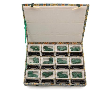 A Chinese Zodiac Set of 12 carved jade figures with ebonized stands in a presentation box.