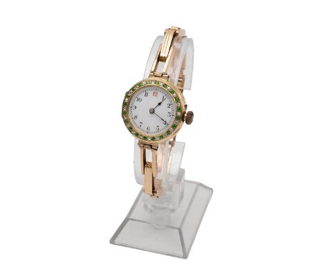 Art Deco 15ct gold wristwatch. Manual wind, 43mm case, gem set bezel, white enamel dial, Arabic hour markers and spade hands.