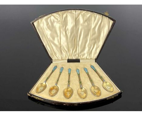 An Edwardian cased set of silver gilt teaspoons, the finial, stem and back of bowl decorated with Cloisonne enamel in green a