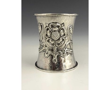 A George V silver Arts and Crafts napkin ring, of waisted cylindrical form, with spot-hammered decoration, embossed with a Tu