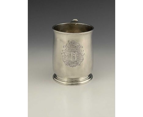 A George II English provincial silver mug, with armorial, of straight-sided cylindrical form, with S scroll handle and step-m