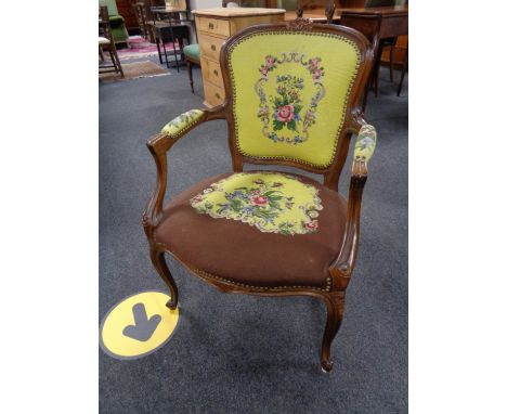 A carved walnut salon armchair in tapestry fabric 