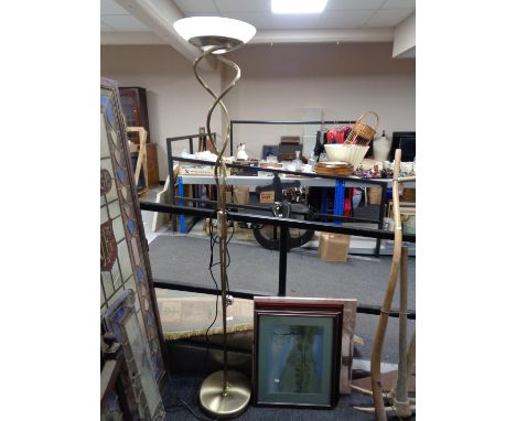 A contemporary floor lamp with four assorted framed pictures 