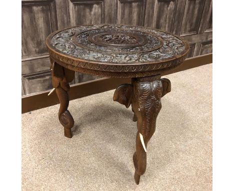 EARLY 20TH CENTURY INDIAN CARVED WOOD CIRCULAR OCCASIONAL TABLE, the table carved with a central deity surrounded by scrollin