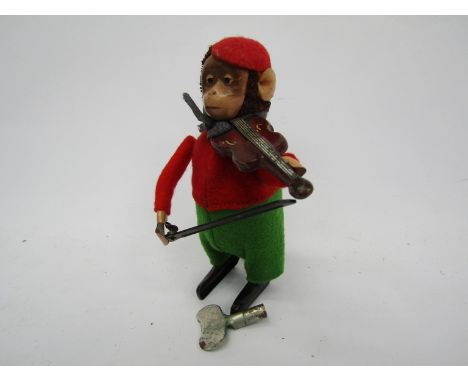 A Schuco clockwork monkey playing violin, with key 