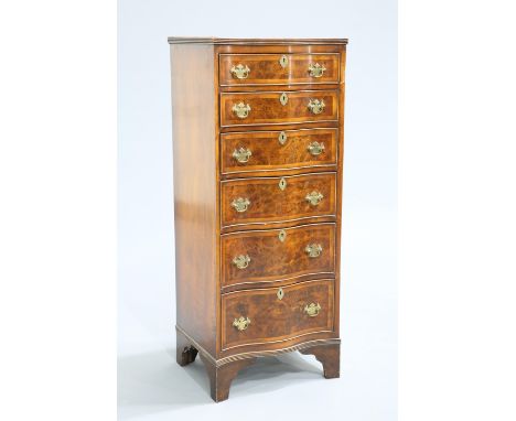 A GEORGIAN STYLE BURR WALNUT TALL BOY, the serpentine top with reeded edge over six conforming graduated drawers with brass h