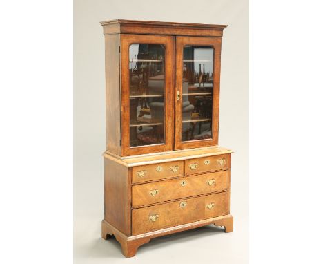 AN EARLY 18TH CENTURY FEATHERBANDED WALNUT CABINET ON CHEST, the upper section with a pair of glazed doors, the base with two