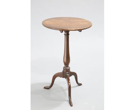 A GEORGE III MAHOGANY TILT-TOP TRIPOD TABLE, the circular top raised on a slender baluster stem continuing to hipped downswep