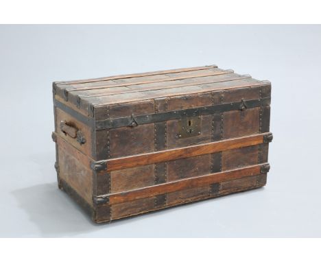 A 19TH CENTURY IRON AND OAK MOUNTED LEATHER TRUNK,&nbsp;rectangular, with flat hinged top and leather carrying handles. 44.5c