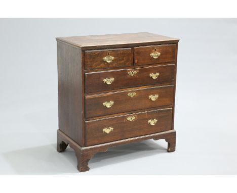 A GEORGE III OAK CHEST OF DRAWERS, the moulded rectangular top over two short over three long graduated drawers, fitted with 