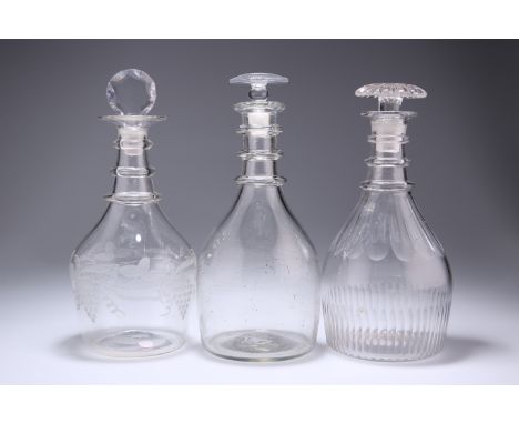 THREE GEORGIAN GLASS DECANTERS, the first with graduated triple ring neck and etched with fruiting vine, the second with trip