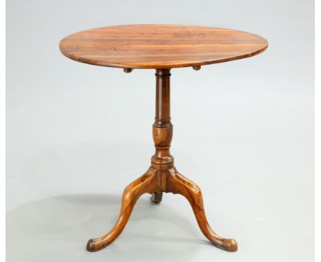 AN 18TH CENTURY YEW WOOD TILT-TOP TRIPOD TABLE, the circular top raised on a baluster stem continuing to hipped downswept leg