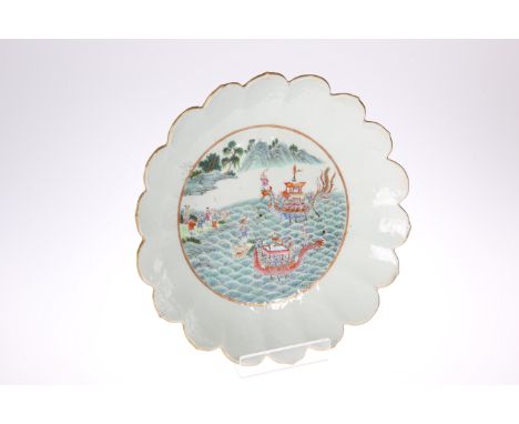 A CHINESE FAMILLE VERTE 'LOTUS' DISH, enamel painted to the well with dragon boats approaching the shore and mountains beyond