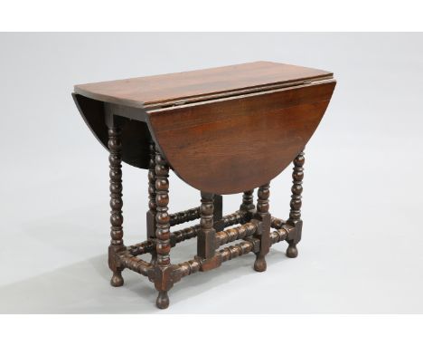 AN EARLY 18TH CENTURY OAK GATELEG TABLE, of small proportions, the twin demilune leaves supported on a bobbin-turned stand. 7