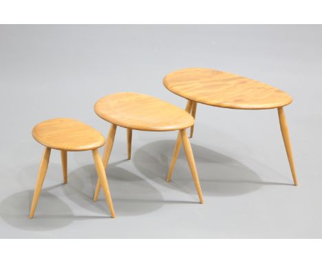 A NEST OF THREE ERCOL BLONDE ELM AND BEECH 'PEBBLE' TABLES, model 354, each labelled. Largest 65cm wide