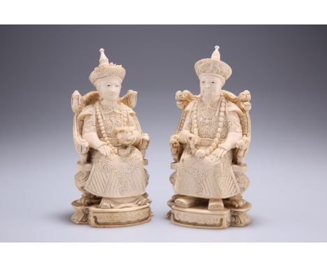 A PAIR OF CHINESE IVORY FIGURES, 19TH CENTURY, carved as a seated emperor and empress, each bears carved seal mark to base. 1