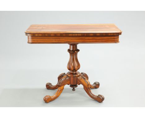 A VICTORIAN ROSEWOOD FOLDOVER CARD TABLE, the moulded rectangular top with rounded corners, raised on a boldly carved reeded 