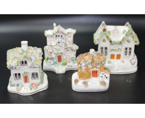 Four various antique ceramic pastille burners each of cottage form, with applied floral decoration. (Largest cottage has some