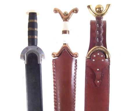 Three modern replicas of Celtic swords and scabbard, two with anthropomorphic boudicca grips.The largest measures 79cm long 