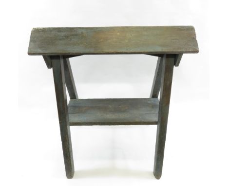 A painted pine sawhorse on out swept legs, with single slatted shelf below, 105cm high, 92cm long, 46cm wide max