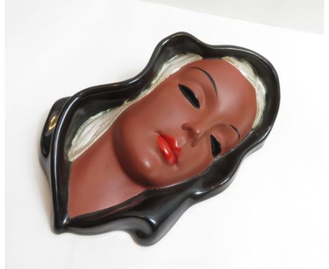 A 20th century Goldscheider mask of a female, with black outline, 20cm high
