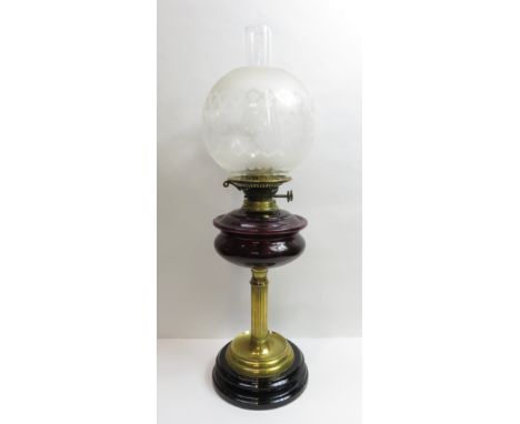 A Victorian oil lamp with a glass reservoir and brass reeded stem, 62cm high