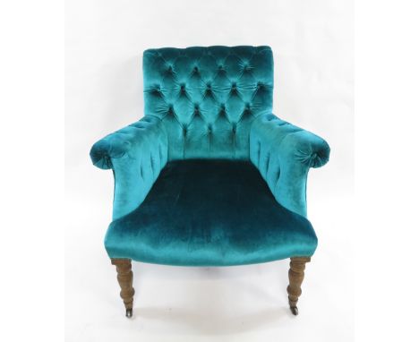 A button back armchair upholstered in velvet teal fabric, on wooden legs