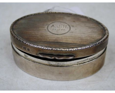 An Edwardian silver trinket jar and cover of oval form having engine turned lid with monogrammed cartouche dated 25.12.9, wei