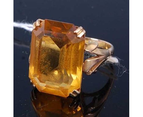 A modern yellow metal and orange citrine tablet ring, having a four claw set baguette cut orange citrine, measuring approx 20