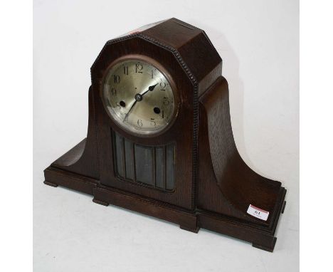 A 1920s oak cased eight-day mantel clock, the silvered dial showing Arabic numerals above a sectional glazed door, standing u