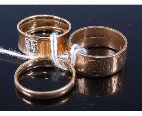 A 9ct gold wedding band, having textured decoration; together with one other 9ct gold band ring; and a yellow metal band ring