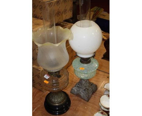 A late Victorian brass oil lamp, the wrythen frosted glass shade with wavy rim above a clear glass font, height 59cm overall,