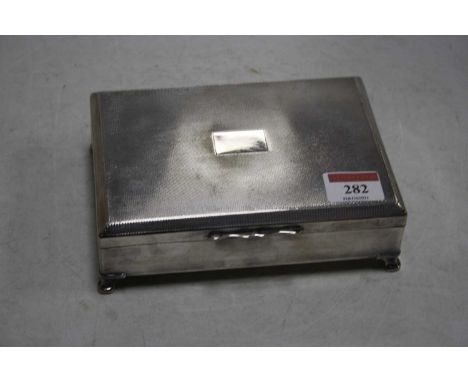 A silver plated table cigarette box of rectangular form having an engine turned hinged lid with vacant cartouche with cedar l