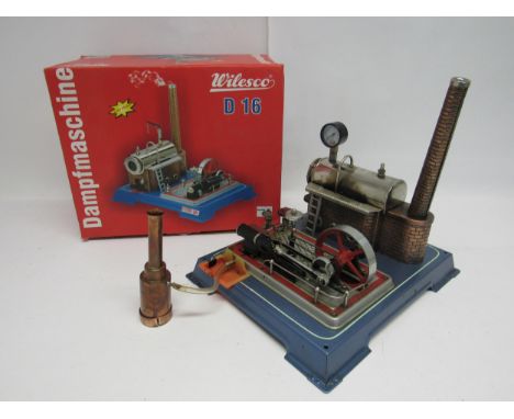 A Wilesco D16 Dampfmaschine live steam stationary engine plant, the horizontal boiler on brickwork effect plinth with chimney