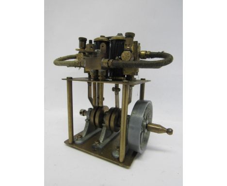 A brass live steam vertical twin cylinder steam engine with flywheel, 11.5cm tall 