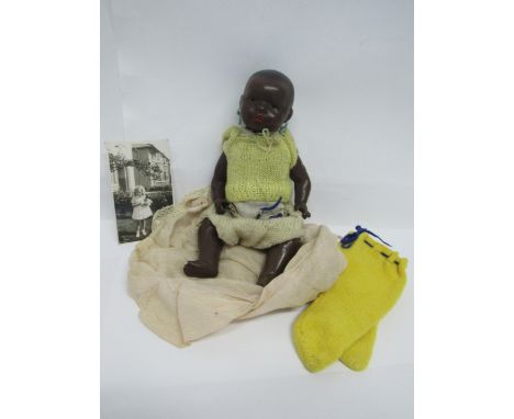 A Heubach Koppelsdorf black bisque baby doll with brown glass sleeping eyes, pierced ears and red painted lips, marked "Heuba